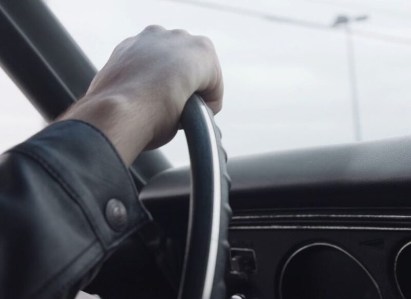 momak u kožnoj jakni vozi automobil