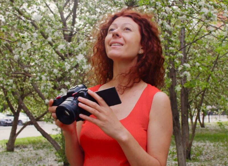 devojka drži fotoaparat u rukama